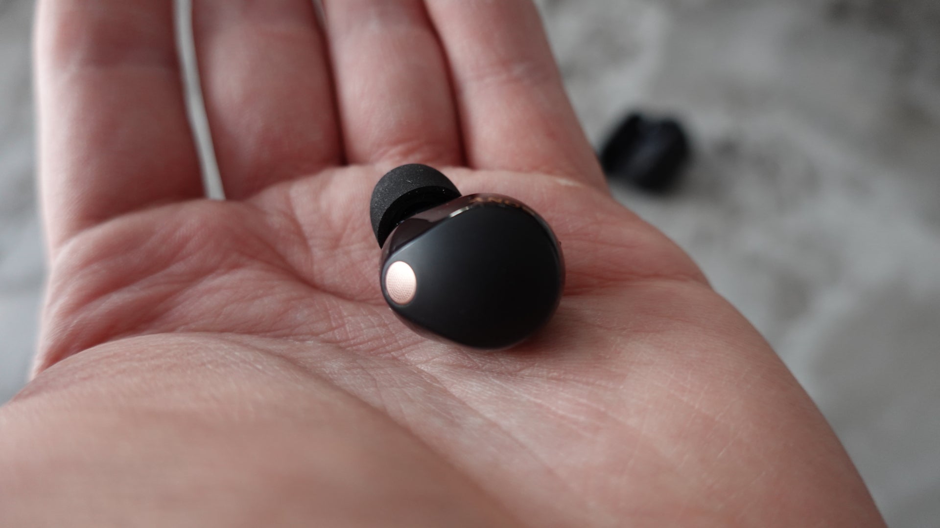 Sony WF-1000XM5 earbud in hand