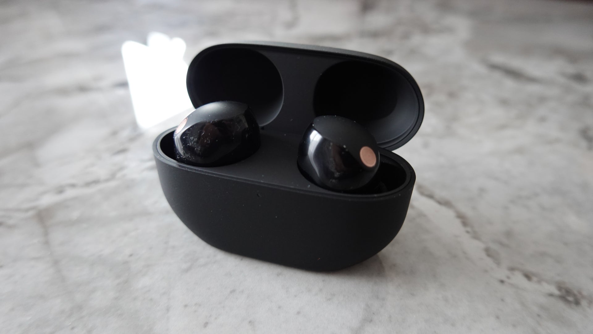 The Sony WF-1000XM5 in case with lid up