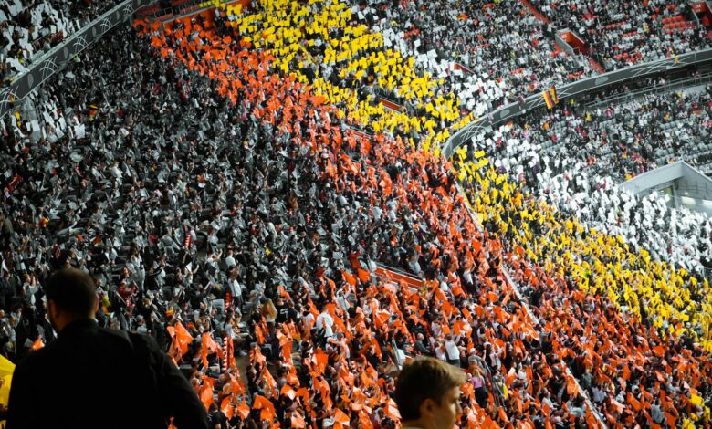 Packed college football stadium with enthusiastic crowd cheering during game