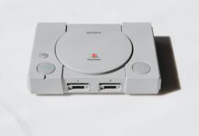 Modern gaming console on entertainment center with controller