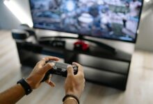 Modern gaming console on entertainment center displaying game selection interface