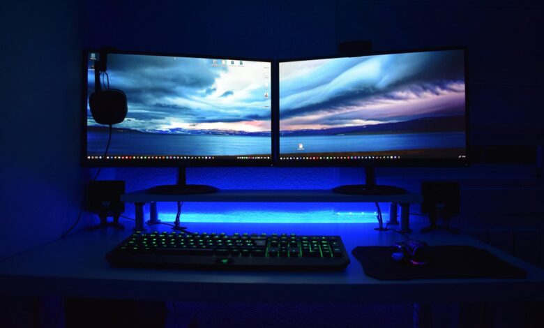Modern PC gaming setup with multiple monitors displaying game libraries