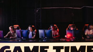 Professional esports tournament setup with gaming stations and large screens for competitive fighting game event