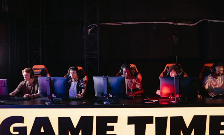 Professional esports tournament setup with gaming stations and large screens for competitive fighting game event