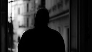 Mysterious hooded figure in shadows representing stealth gameplay mechanics