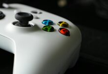 Modern gaming controller next to console representing subscription gaming services