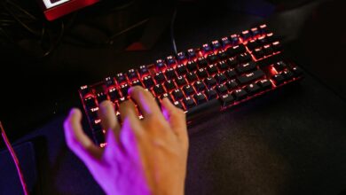 Close-up of illuminated mechanical gaming keyboard with RGB backlighting on dark gaming desk