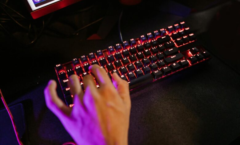 Close-up of illuminated mechanical gaming keyboard with RGB backlighting on dark gaming desk