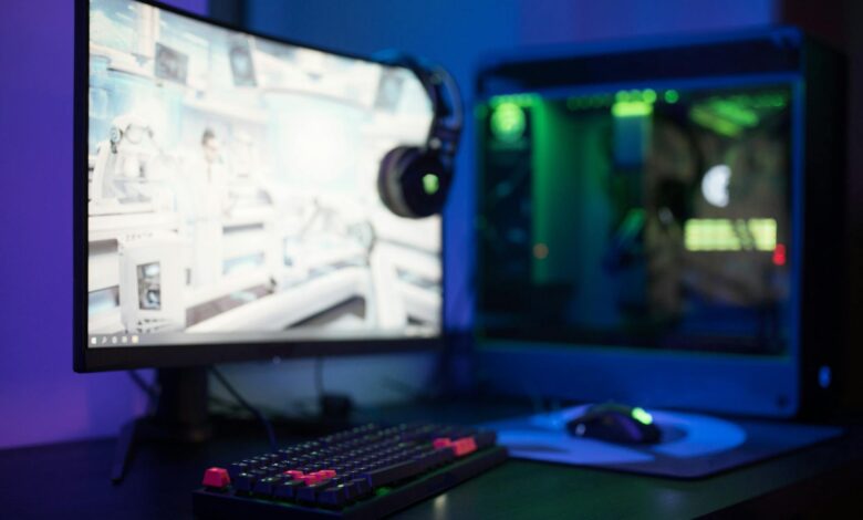 Modern gaming computer setup with multiple monitors displaying game development interface