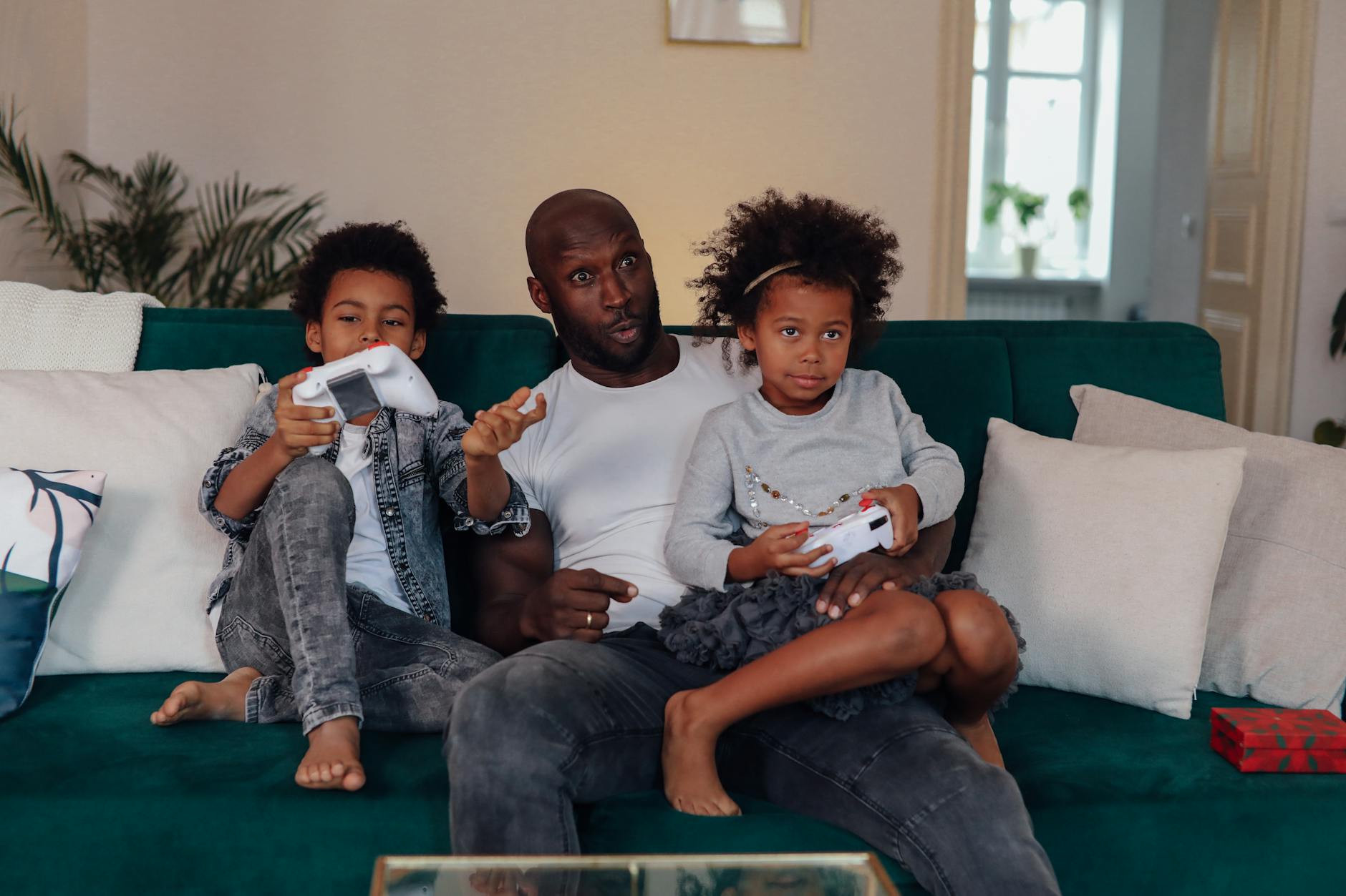 People playing video games together on couch with controllers in comfortable living room