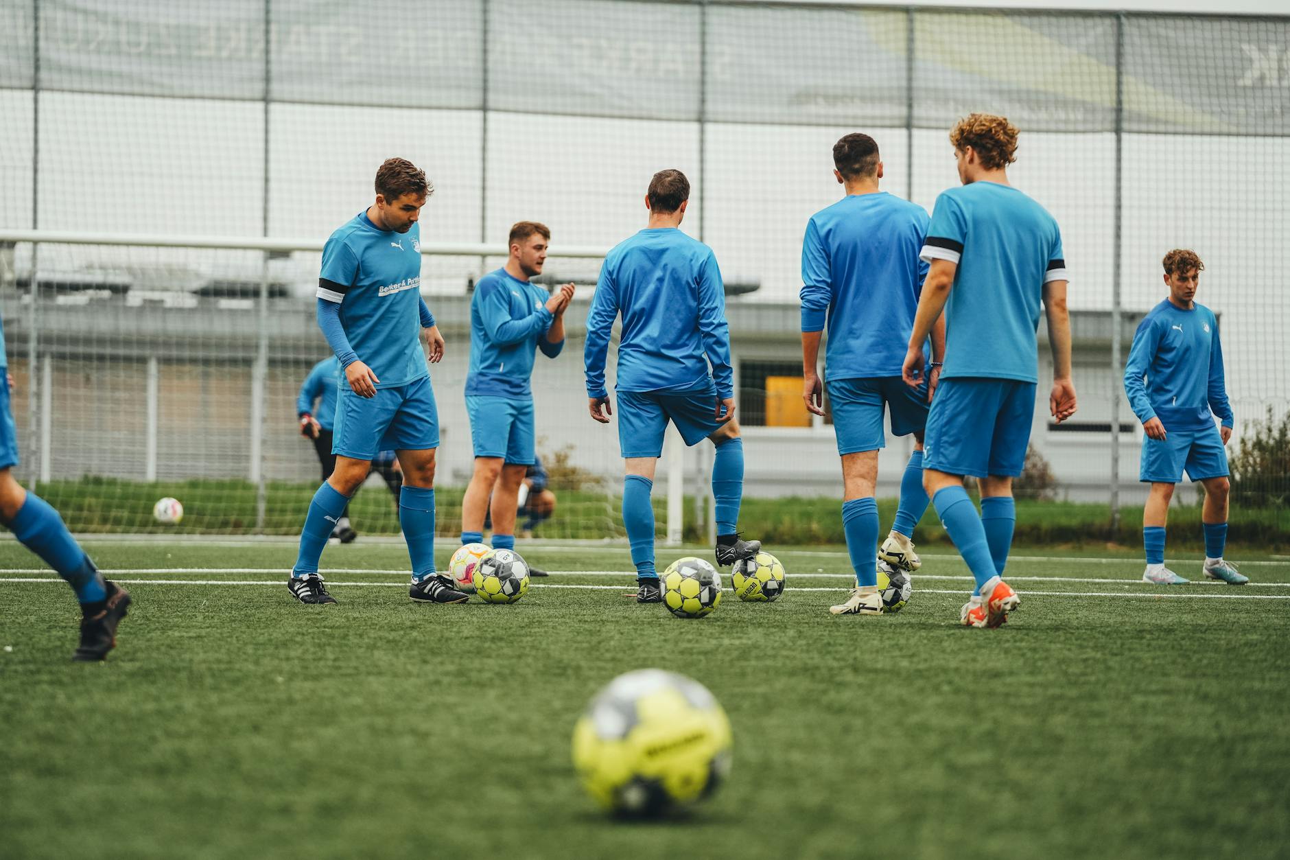 Soccer players training on practice field with cones and equipment