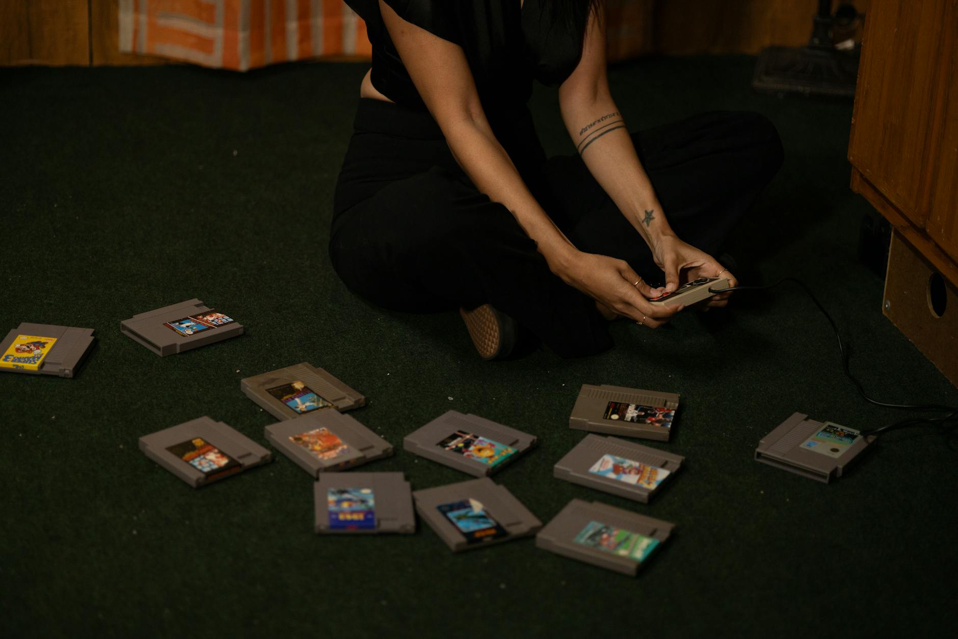 Video game cartridges arranged on wooden surface showing physical media collection