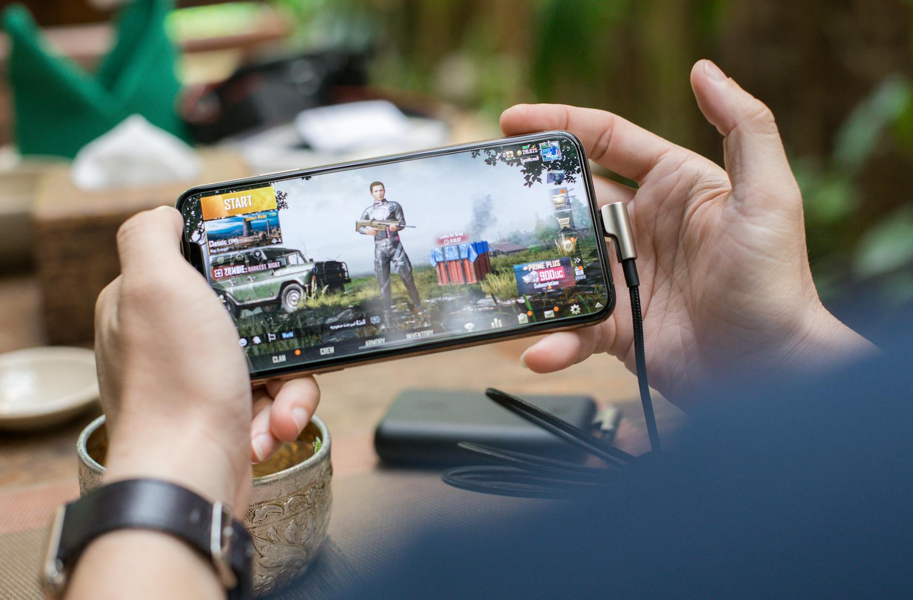 Person playing mobile games on smartphone representing expanded gaming platforms