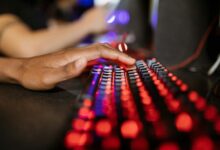 Mechanical gaming keyboard with RGB backlighting on dark desk surface