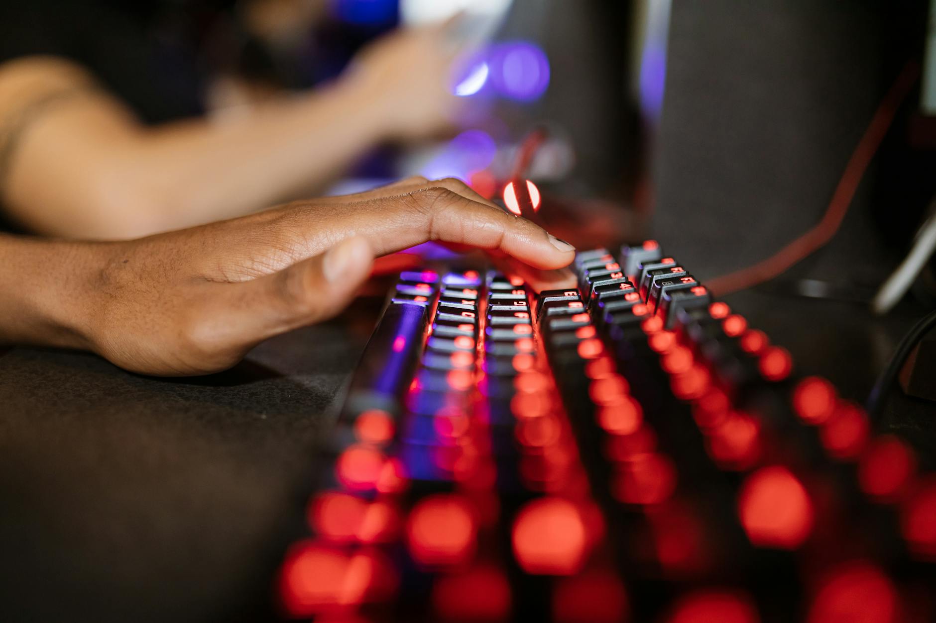 Mechanical gaming keyboard with RGB backlighting on dark desk surface