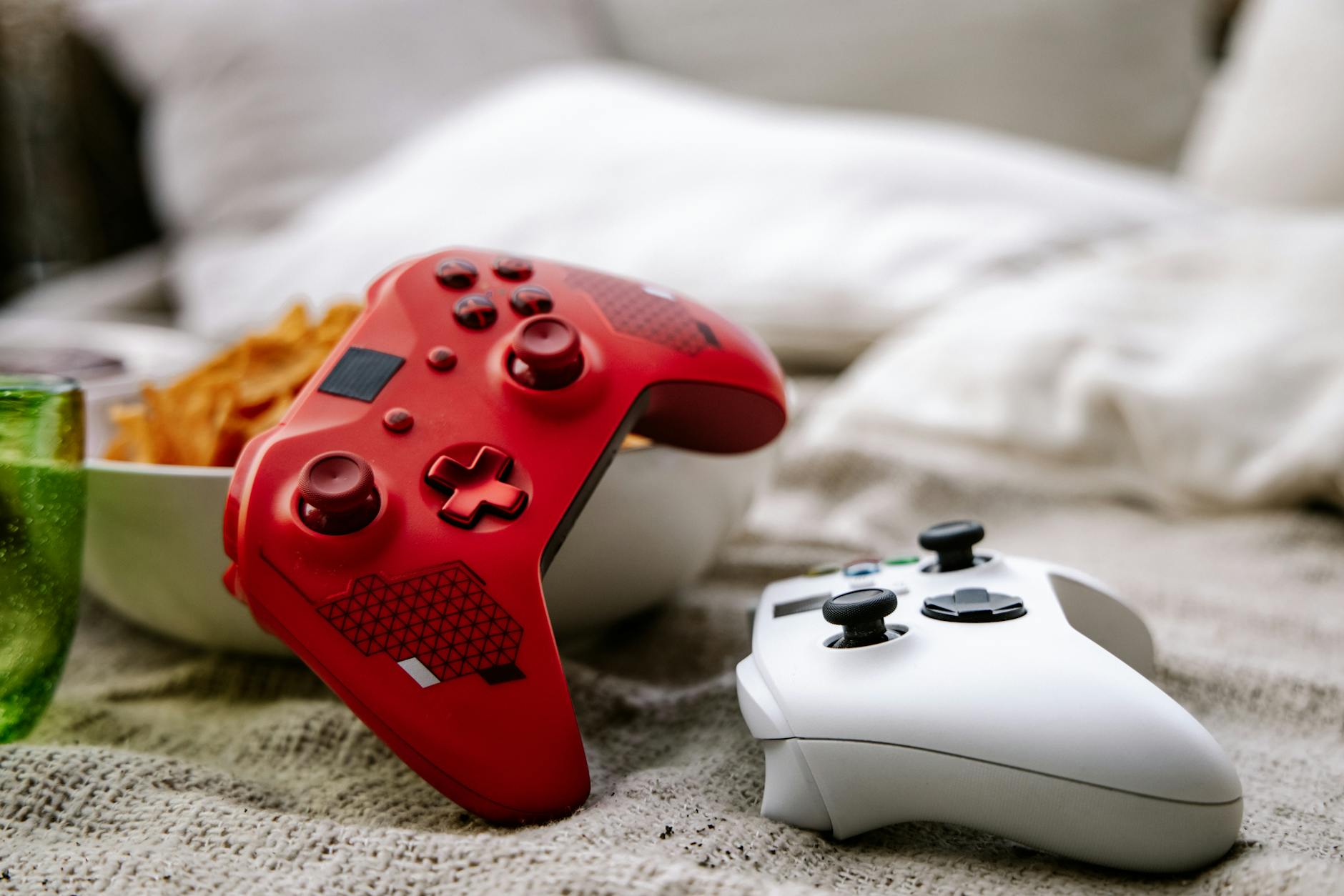 Person playing video games on a couch using a wireless controller connected to a TV