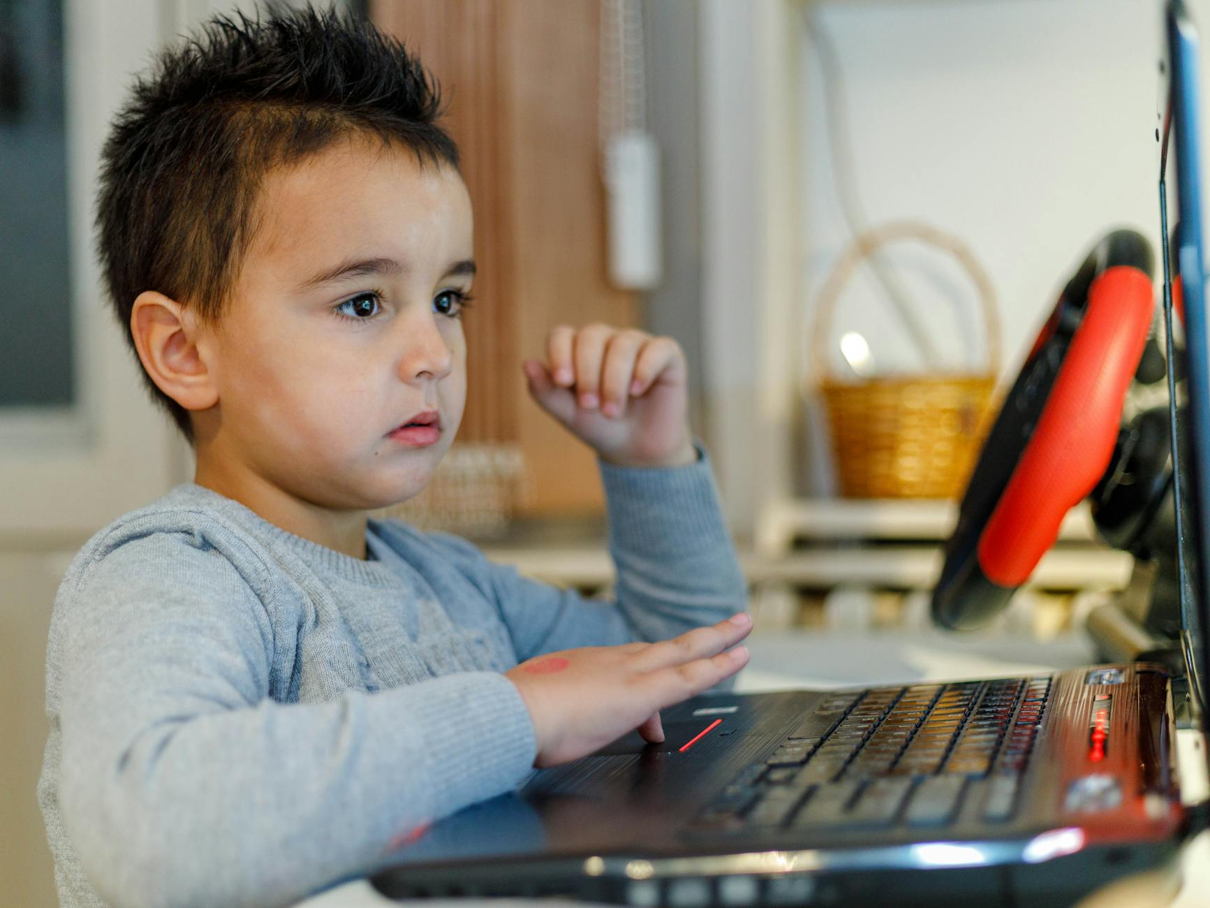 A person playing a video game on a thin laptop computer