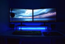 Two OLED gaming monitors displayed side by side on a PC gaming desk setup
