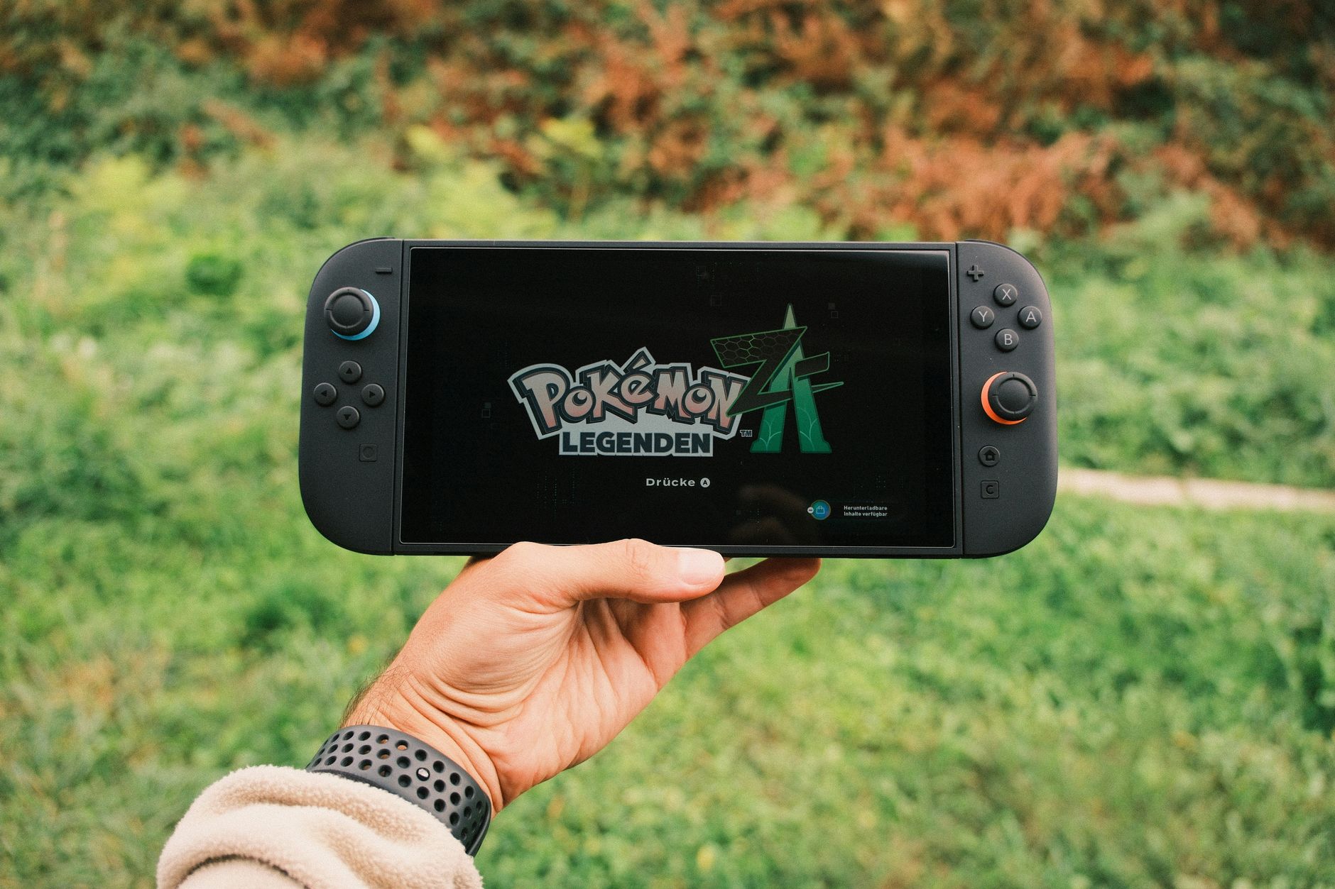 A handheld gaming PC device held in two hands during gameplay