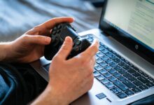 High-end gaming laptop open on a desk displaying a graphics-intensive game