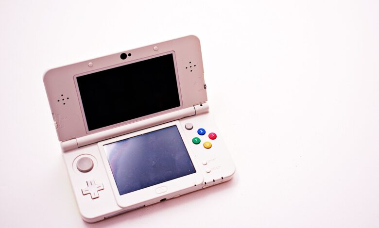A handheld PC gaming device held in two hands against a neutral background