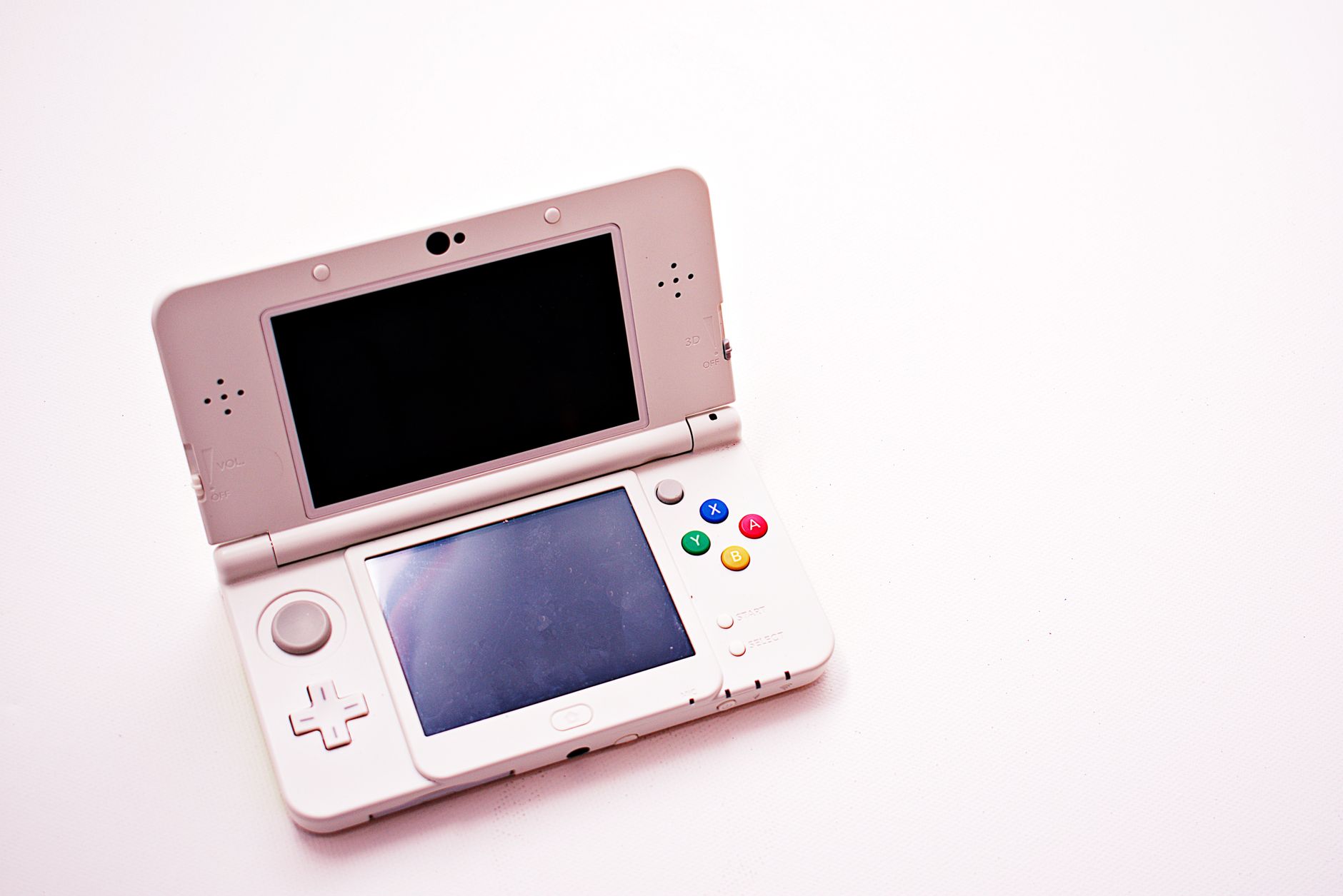 A handheld PC gaming device held in two hands against a neutral background