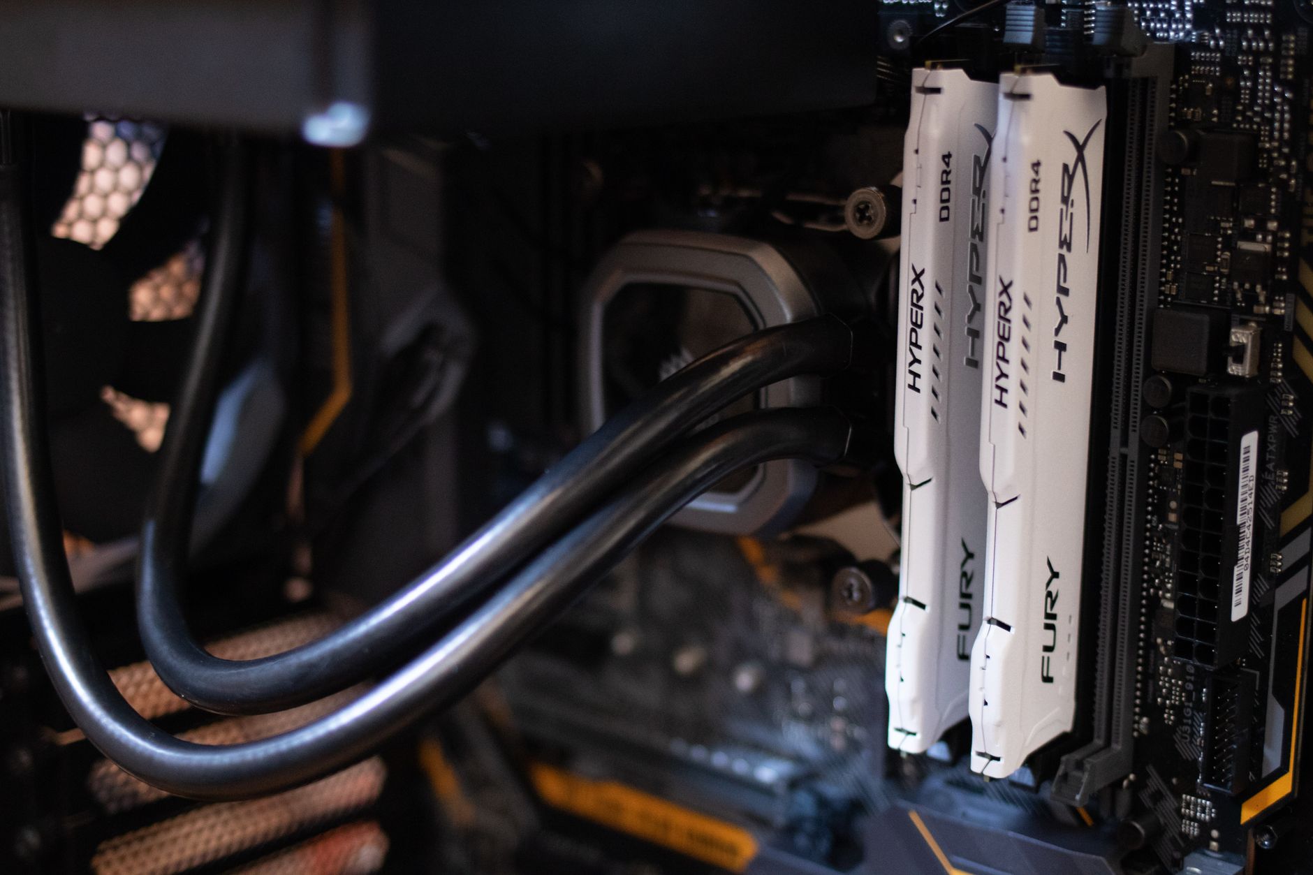 Gaming PC setup during hardware stress testing with monitoring software on screen