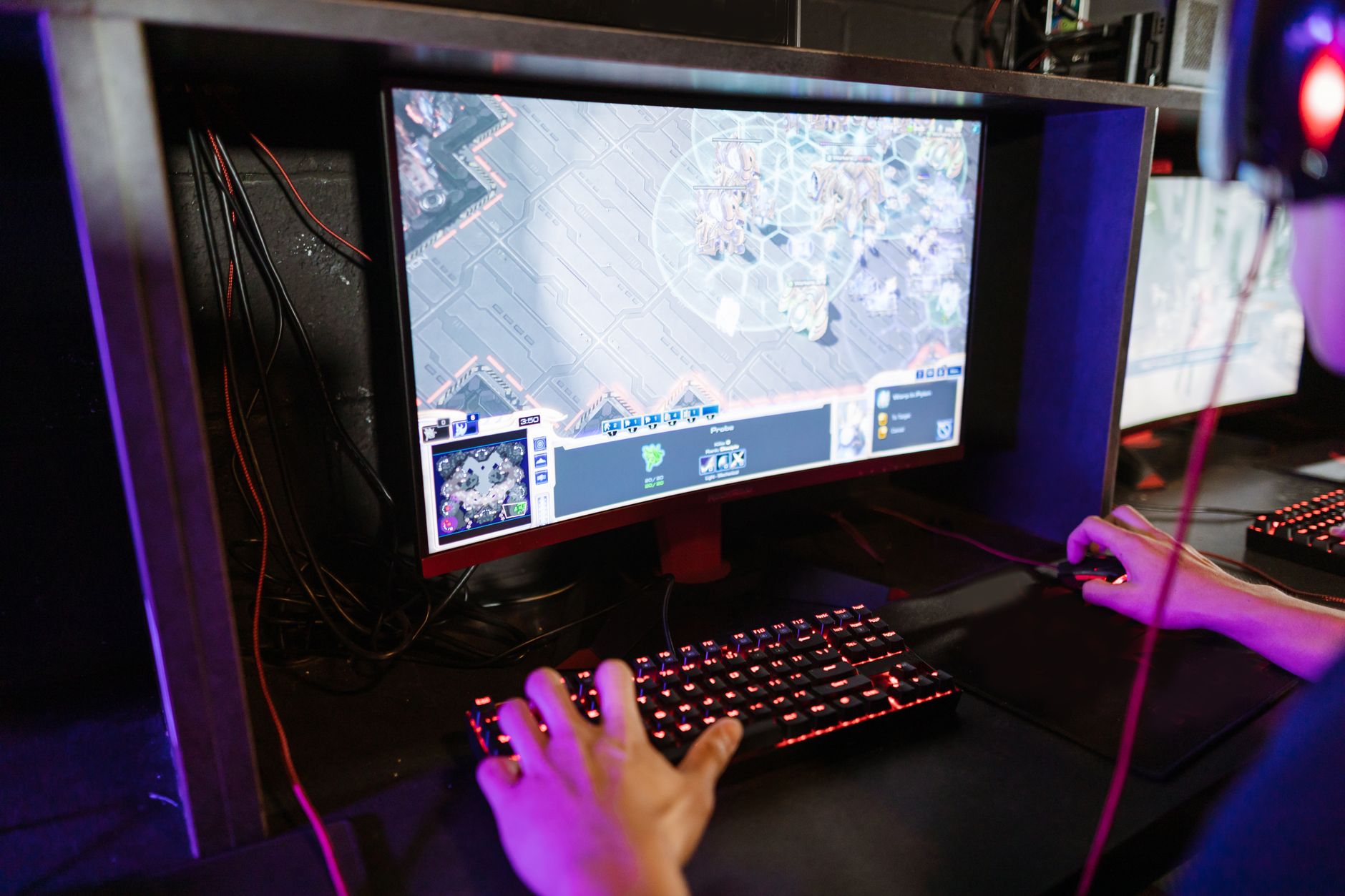 A high-resolution gaming monitor displaying a detailed open-world game scene at 1440p