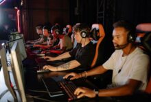 Packed esports arena with stage lighting during a live competitive event